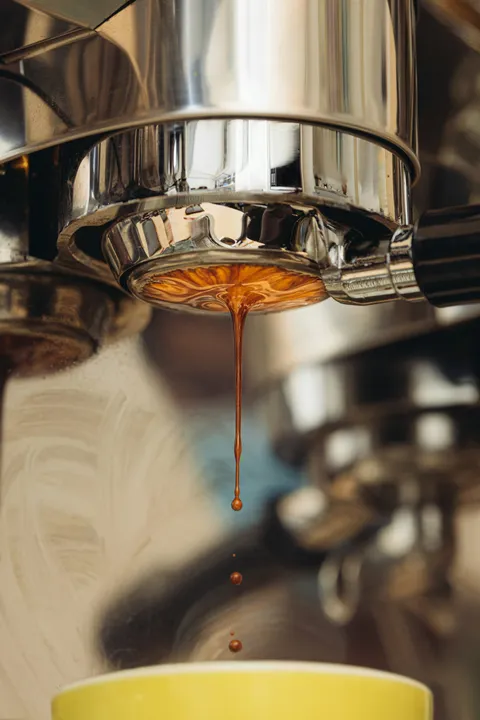 Espresso die uit een metalen filterhouder loopt