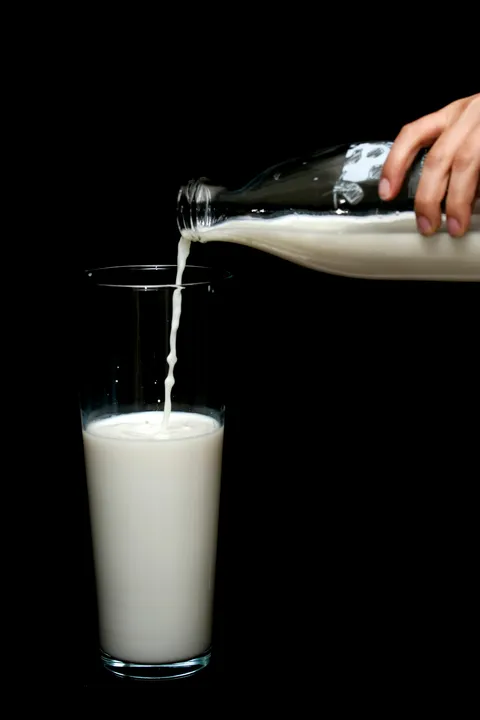 Melk schenken in een doorzichtig glas