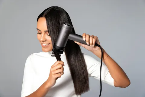 Vrouw föhnt haar haar