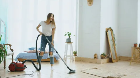 Vrouw stofzuigt een lichte woonkamer